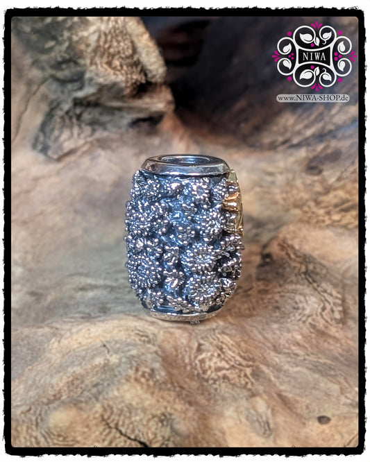 Seitenansicht des CHINESE PEACE BARRELCHARM aus 925 STERLINGSILBER mit CHRYSANTHEMENRELIEF und seitlich angeschnittenem 18K GELBGOLD SCHRIFTZEICHEN, fotografiert auf einer Holzstruktur.