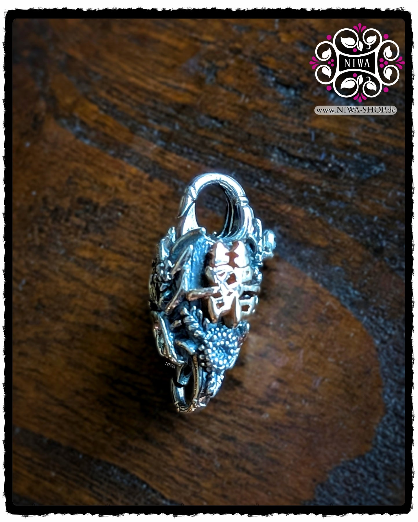 CHINESE DOUBLE HAPPINESS Lock made of 925 STERLING SILVER with Chinese DOUBLE HAPPINESS characters in 18K ROSE GOLD as a front view, surrounded by detailed LOTUS FLOWERS, taken on a dark wooden surface.