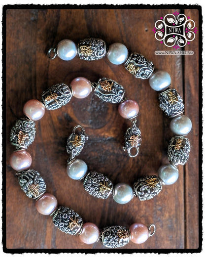 Chinese Sign Series_Sets - two arranged bracelets from the CHINESE series by MAMA MALA with complete sets of CHARM Barrels and LOCKS in 925 STERLING SILVER and 18K gold on a dark wooden surface: below a design with pink beads and ROSE GOLD characters, above a design with white to soft gray beads and YELLOW GOLD characters, both with finely crafted Chinese symbols and floral reliefs.