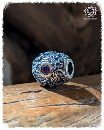 CHANG ERAWAN BarrelCharm, TWOTONE 925 STERLINGSILBER mit 18K GELBGOLD Fassung, violetter AMETHYST, liegende Ansicht mit großer Durchbohrung, auf TEAKWOOD HOLZ, HIMMAPAN Serie, MAMA MALA by NIWA
