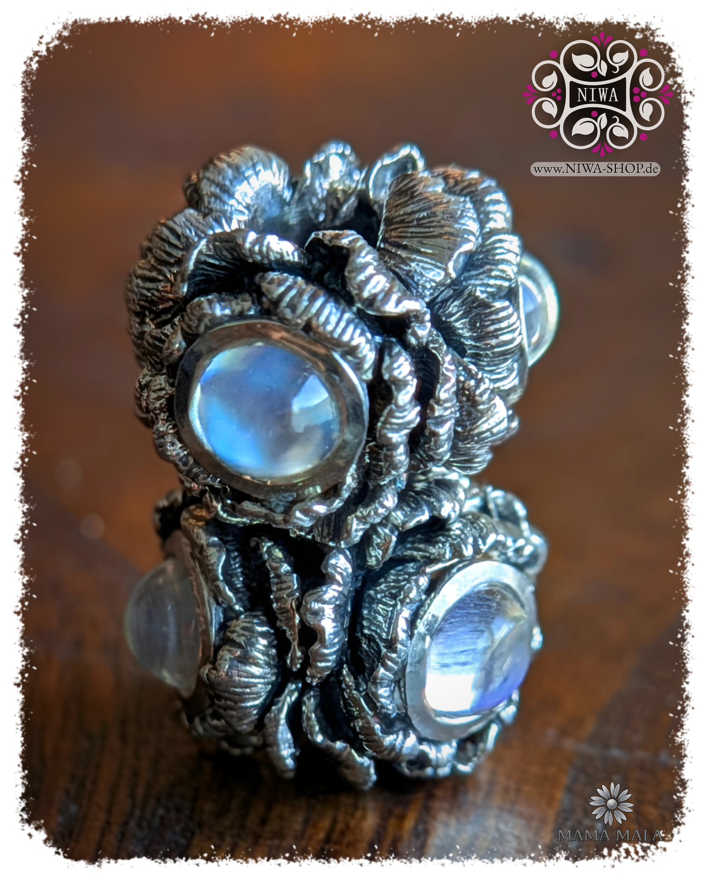 POPPY BLOOM charm made of solid 925 sterling silver with 3x blue moonstone cabochons, two charms in an angled view on wood, MAMA MALA by NIWA