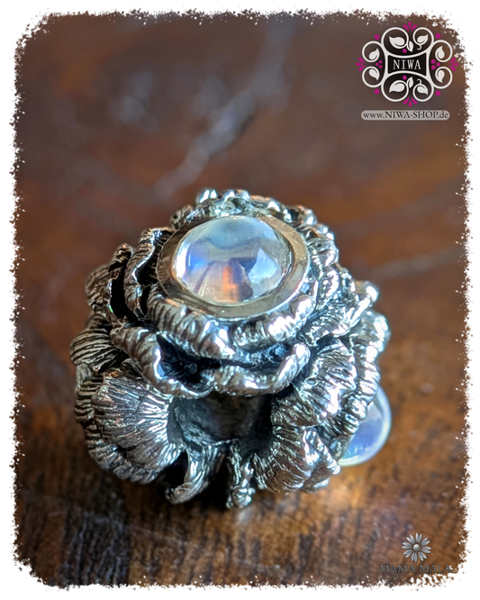 POPPY BLOOM Charm aus massivem 925 SterlingSilber mit 3x Blue Moonstone Cabochon, Seitenansicht auf Holz, MAMA MALA by NIWA