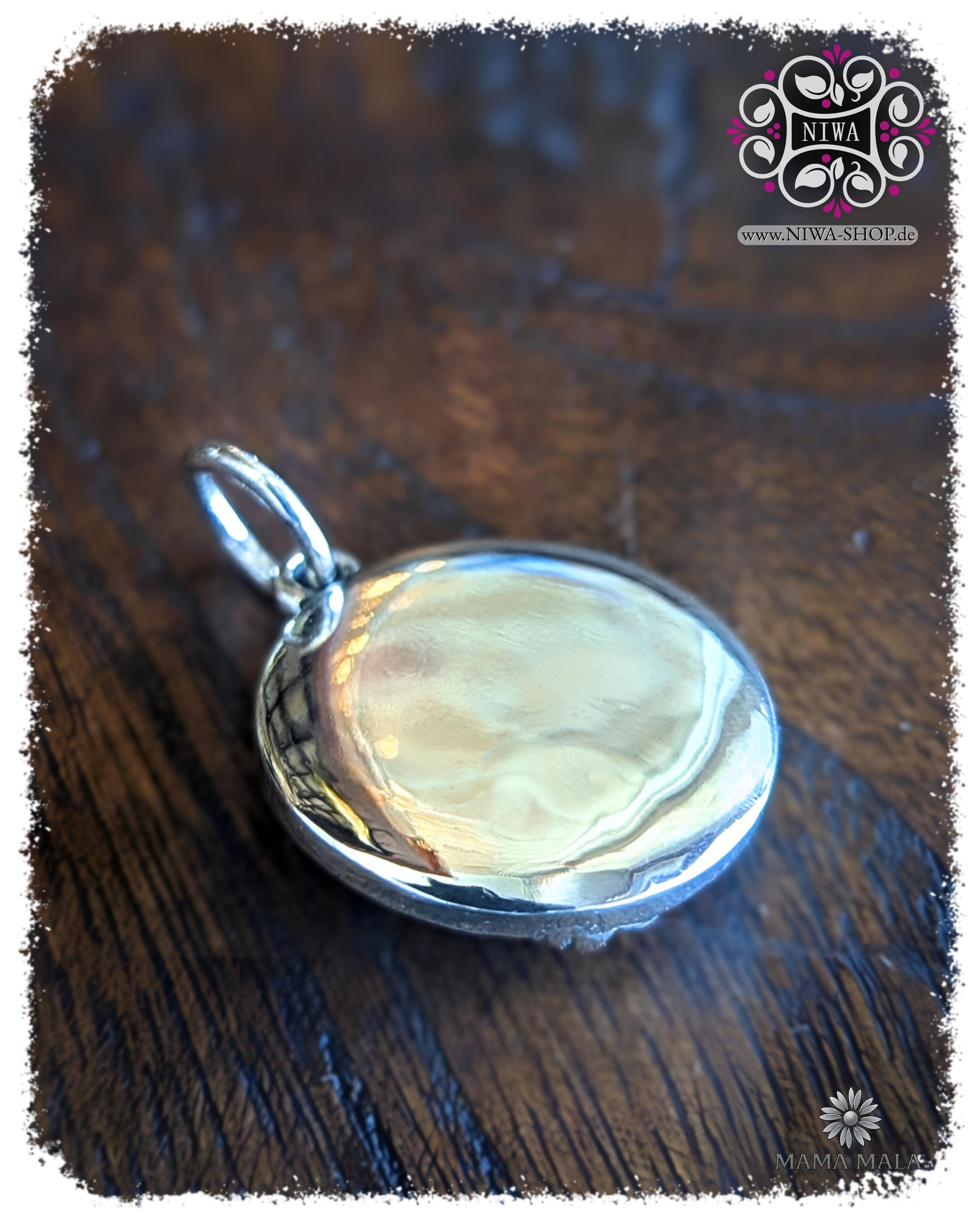 Rückseite des PANG RAM PUENG COIN Dangle aus massivem 925 SterlingSilber, glatt polierte Rückseite mit Öse auf dunklem Holz.