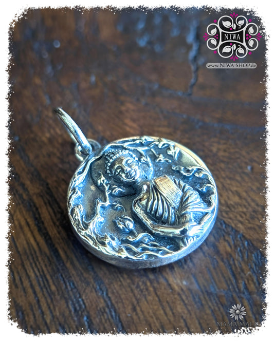 PANG THAWAI NET COIN Dangle in seitlicher Ansicht, detailreicher Sonntagsbuddha aus 925 SterlingSilber mit verschränkten Armen und organischem Relief auf dunkler Holzstruktur.