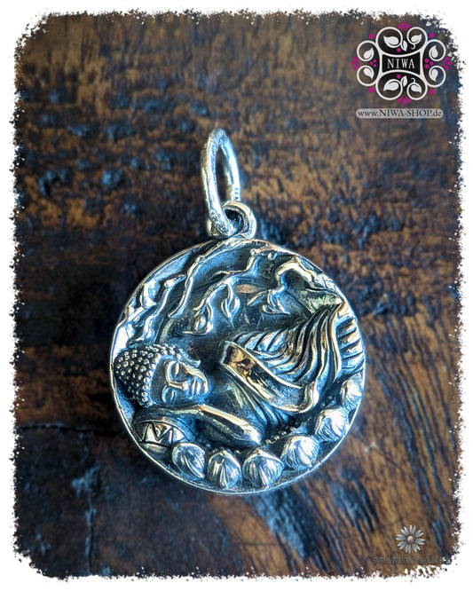 Dienstagsbuddha Dangle PANG SAI YAT COIN aus massivem 925 SterlingSilber, runder Buddha Coin mit liegendem Buddha als Symbol für Ruhe und innere Gelassenheit auf dunklem Holz.