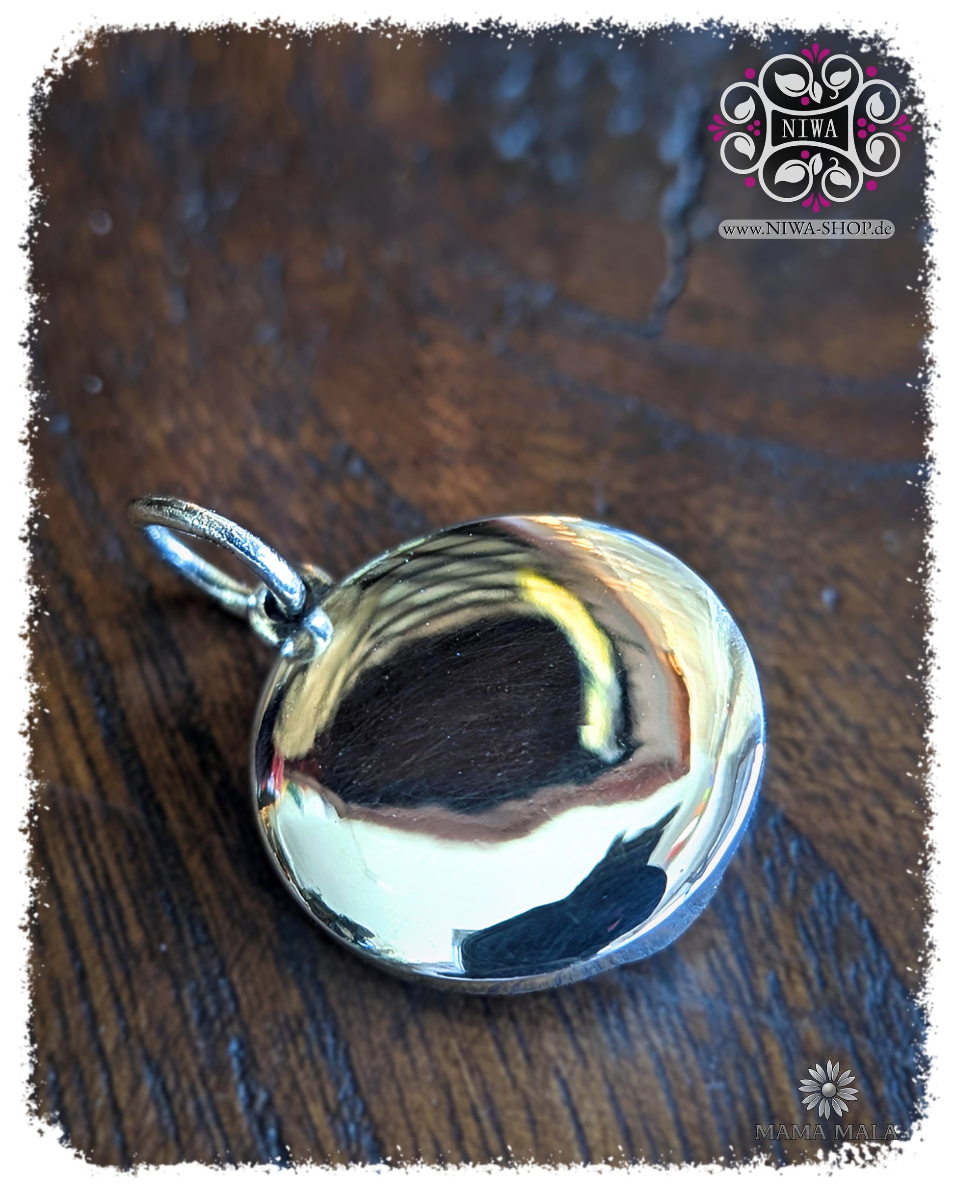 Rückseite des PANG UMBAT COIN Dangle aus massivem 925 SterlingSilber, glatt polierte Rückseite mit Öse auf dunklem Holz.