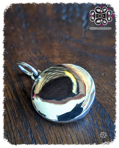 Rückseite des PANG UMBAT COIN Dangle aus massivem 925 SterlingSilber, glatt polierte Rückseite mit Öse auf dunklem Holz.