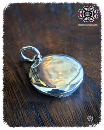 Rückseite des PANG PA LE LAI COIN Dangle aus massivem 925 SterlingSilber, glatt polierte Rückseite mit Öse auf dunklem Holz.