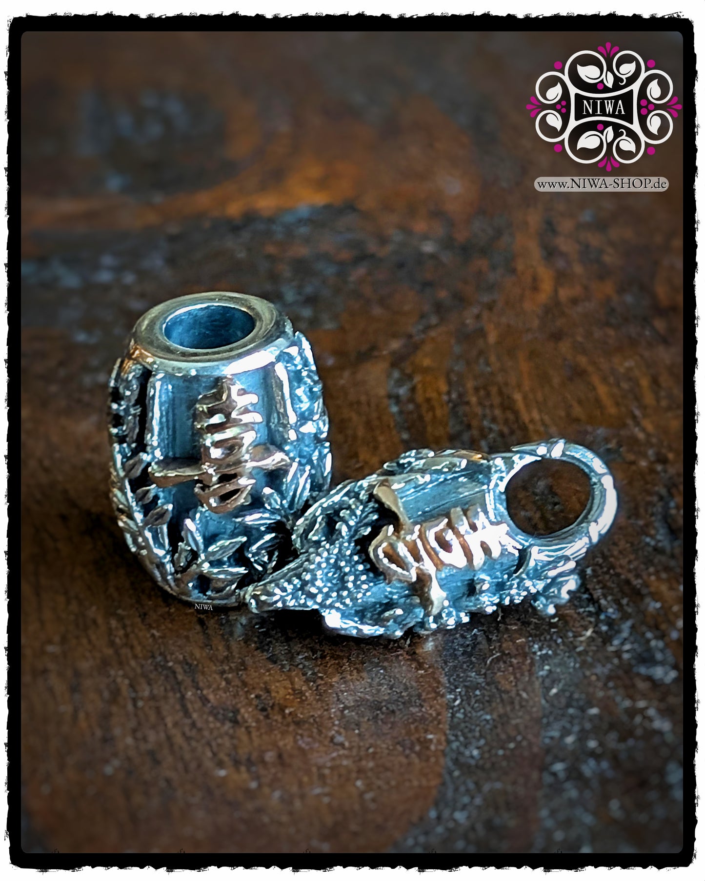 Set aus CHINESE JOY BarrelCharm und CHINESE JOY Lock aus 925 SterlingSilber mit 18K RoséGold Schriftzeichen, auf Holz liegend, zeigt das Zusammenspiel von BAMBUSRELIEF und chinesischem JOY Symbol auf Charm und Lock.