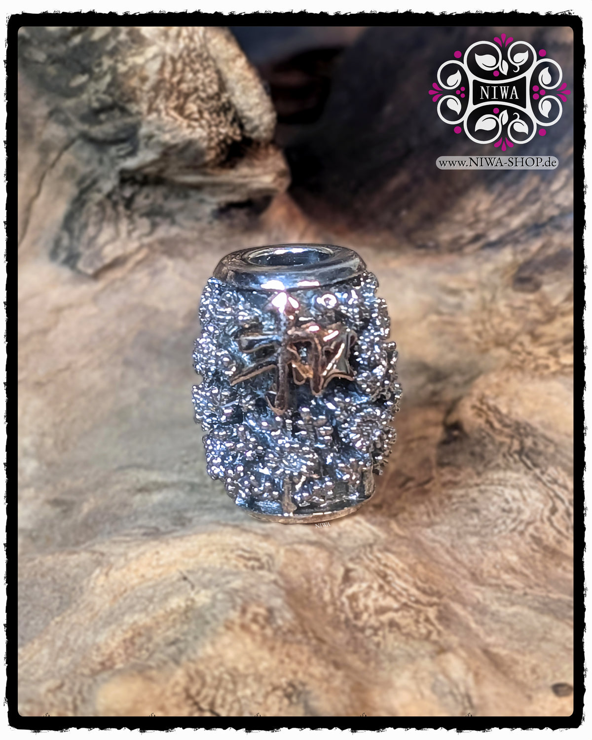 CHINESE PEACE BARRELCHARM made of 925 STERLING SILVER with CHRYSANTHEMUM RELIEF and 18K ROSE GOLD CHARACTERS on the front, taken frontally on a warm wooden background.