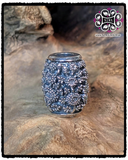 Rückansicht des CHINESE PEACE BARRELCHARM aus 925 STERLINGSILBER ohne Schriftzeichen, komplett von dicht gearbeiteten CHRYSANTHEMENBLÜTEN bedeckt, auf natürlichem Holzuntergrund.