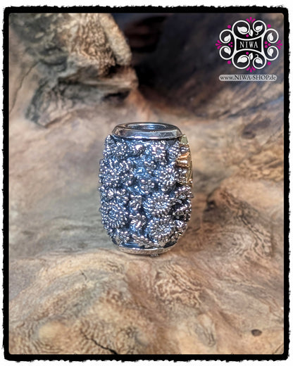 Seitenansicht des CHINESE PEACE BARRELCHARM aus 925 STERLINGSILBER mit CHRYSANTHEMENRELIEF und seitlich angeschnittenem 18K GELBGOLD SCHRIFTZEICHEN, fotografiert auf einer Holzstruktur.