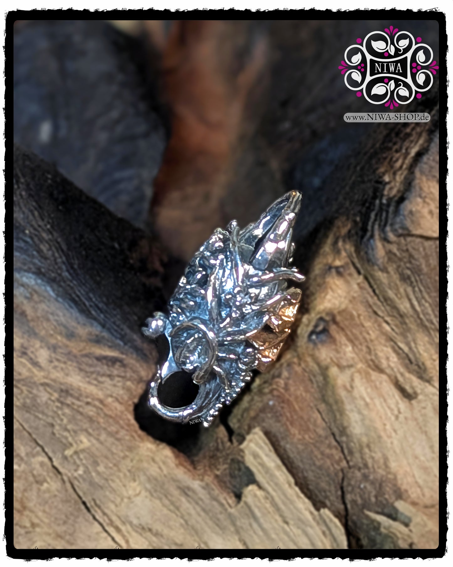 Side view of the CHINESE PEACE Lock from MAMA MALA by NIWA, detailed chrysanthemum relief with 18K rose gold characters visible on the side and an implied locking bracket, lying in a recess in the wooden background.