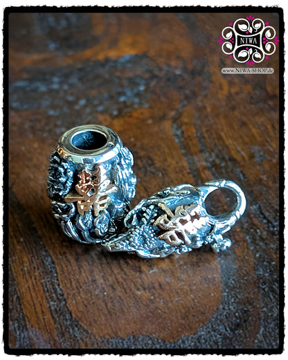 CHINESE DOUBLE HAPPINESS BarrelCharm and matching CHINESE DOUBLE HAPPINESS Lock made of 925 STERLING SILVER with 18K ROSE GOLD characters, decoratively arranged together on a dark wooden surface.