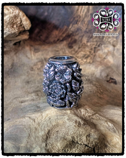 CHINESE DOUBLE HAPPINESS BarrelCharm aus 925 SterlingSilber ohne sichtbares Goldzeichen, Rückansicht mit detailreichem LOTUS-Relief vor Holz-Hintergrund.