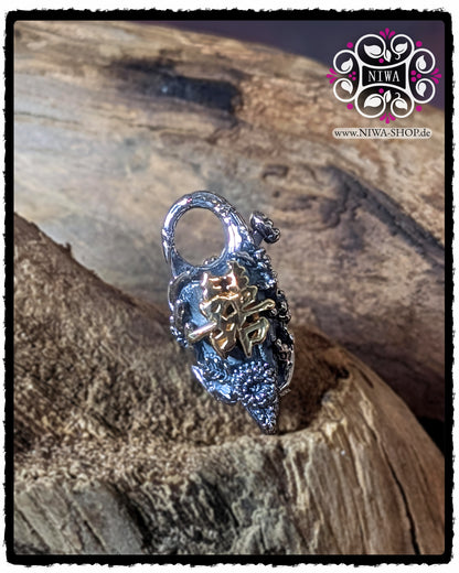 CHINESE DOUBLE HAPPINESS Lock front view with raised DOUBLE HAPPINESS lettering made of 18K yellow gold on a structured LOTUS and flower surface made of 925 STERLING SILVER, presented on wood.