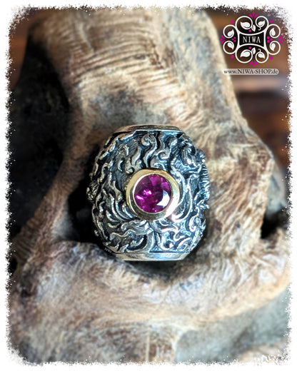 CHANG ERAWAN BarrelCharm, TwoTone 925 SterlingSilber und 18K GelbGold, rosa Granat in 18K GelbGold Fassung, HIMMAPAN Serie, ASIA Kollektion, MAMA MALA by NIWA, Makroaufnahme auf TEAKWOOD Holzwurzel