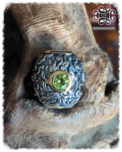 CHANG ERAWAN BarrelCharm, TwoTone 925 SterlingSilber und 18K GelbGold, grüner Peridot in 18K GelbGold Fassung, HIMMAPAN Serie, ASIA Kollektion, MAMA MALA by NIWA, Makroaufnahme auf TEAKWOOD Holzwurzel