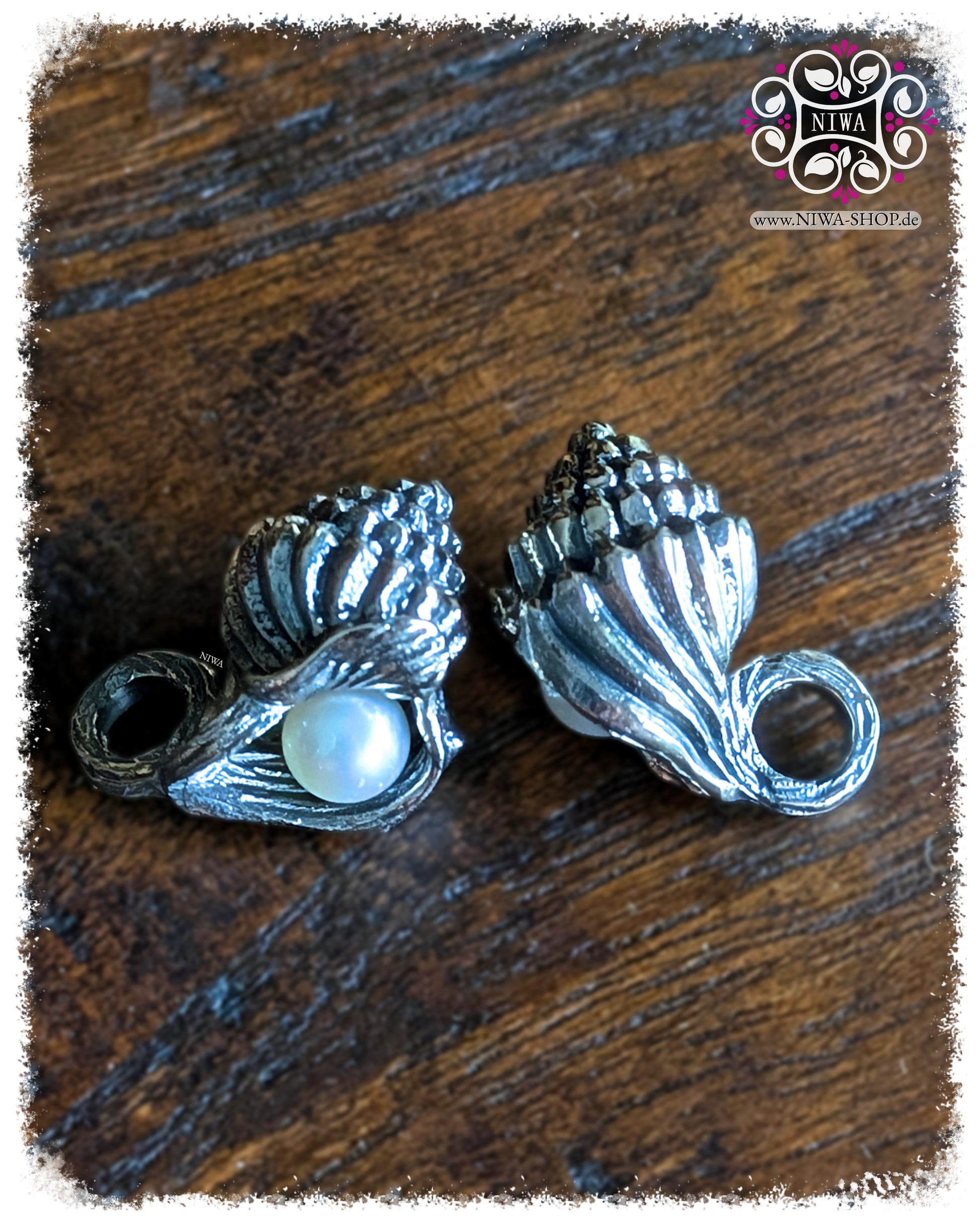 NIWABEADS SEASHELL NUTMEG DANGLE, OCEAN Collection, MYSTIC PEARL Serie, 925 STERLINGSILBER, detailreiche Muschelform mit lüsterweißer AGOYA PERLE, auf dunklem Holzhintergrund