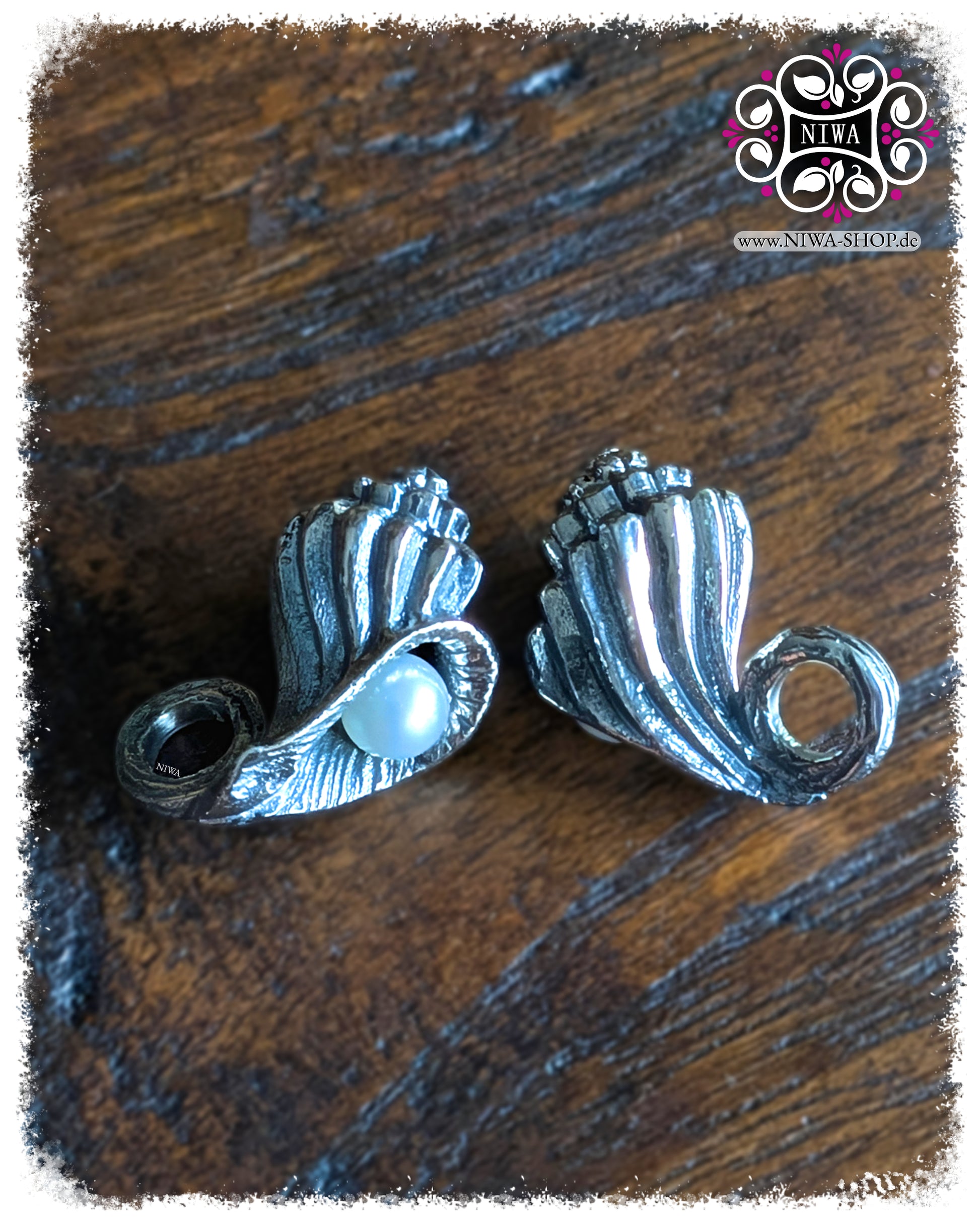 NIWABEADS SEASHELL CONCH DANGLE, OCEAN Collection, MYSTIC PEARL Serie, 925 STERLINGSILBER Muschel mit eingerollter Form und AGOYA PERLE in Lüsterweiß, Detailaufnahme auf dunklem Holzhintergrund