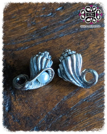 NIWABEADS SEASHELL CONCH DANGLE, OCEAN Collection, MYSTIC PEARL Serie, 925 STERLINGSILBER Muschel mit eingerollter Form und AGOYA PERLE in Lüsterweiß, Detailaufnahme auf dunklem Holzhintergrund