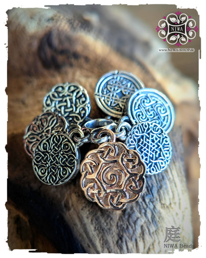 INFINITY COINS DangleSpacer von NIWABeads in TwoTone Roségold mit sieben ornamentalen Coins aus 925 SterlingSilber und großem Mittelcoin in 14K Roségold, frontal auf Holz inszeniert.
