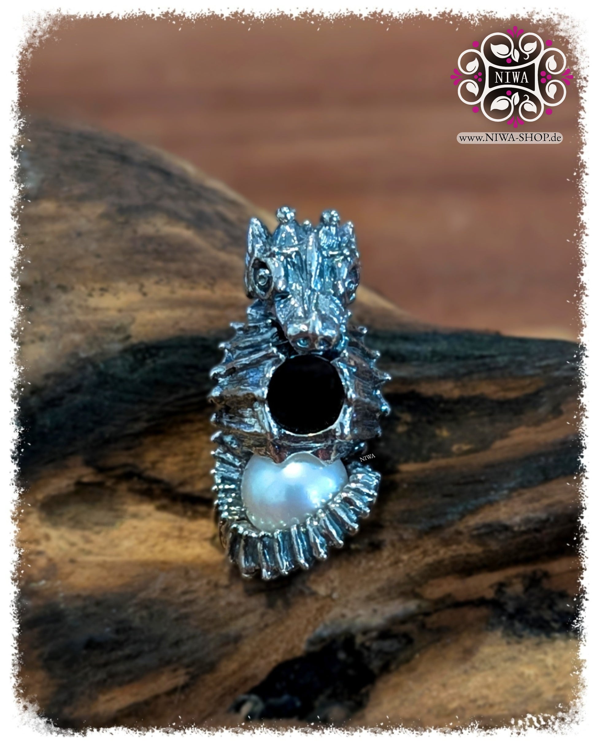 SEAHORSE Charm NIWABeads OCEAN Kollektion, Frontansicht, 925 SterlingSilber mit LUSTRE-WEISS Salzwasserperle im eingerollten Schweif, Makro auf Holz